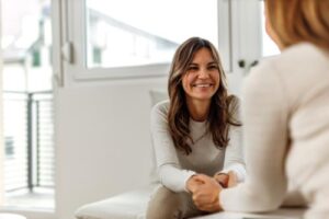 smiling woman speaking with her addiction treatment specialist about the Pathways to Recovery Program in Colorado.